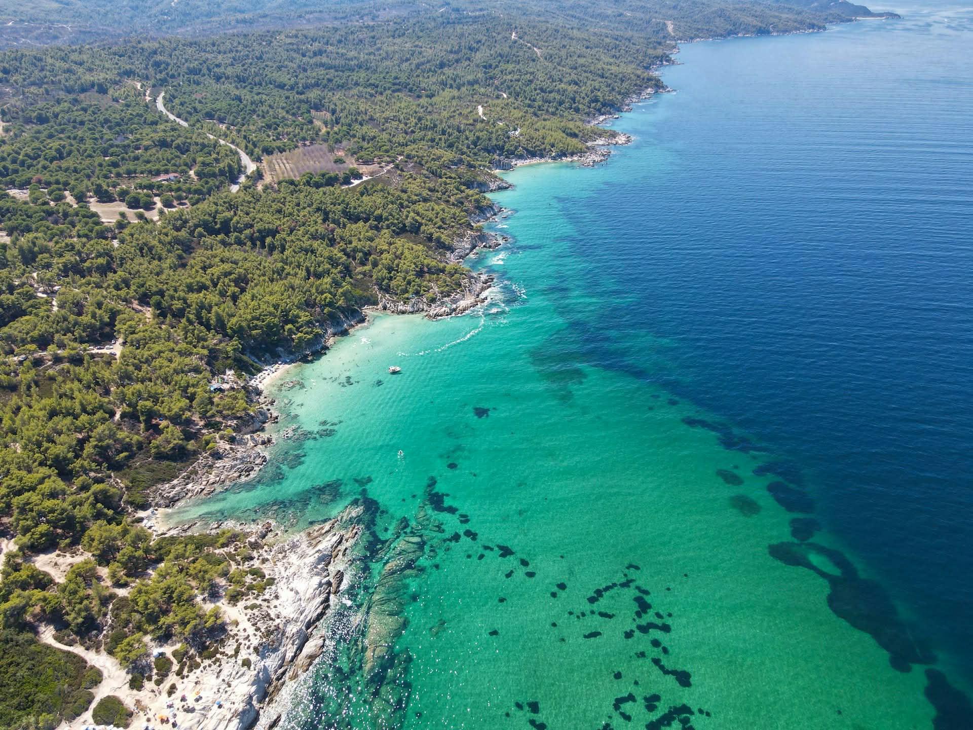 Aerial view of Halkidiki coastline with turquoise waters and pine forests in Northern Greece Crystal clear waters and pine-covered coastline of Halkidiki, one of the most beautiful seaside destinations in Northern Greece.